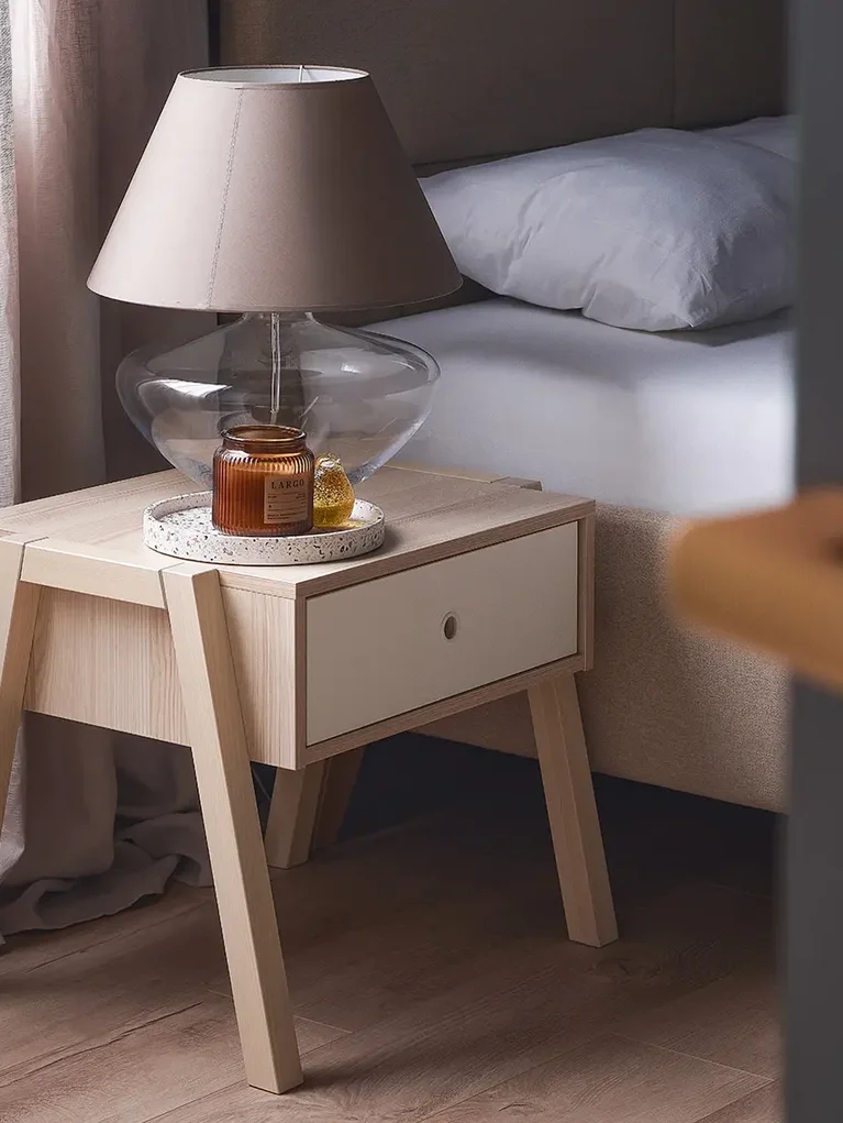lampa ze szklaną podstawą stoi przy łóżku
